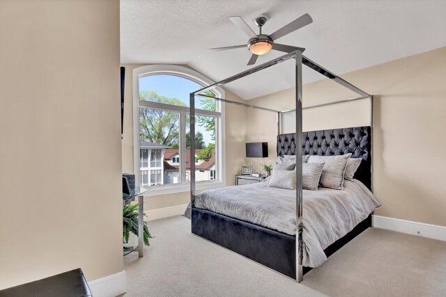 carpeted bedroom with ceiling fan, lofted ceiling, and a textured ceiling