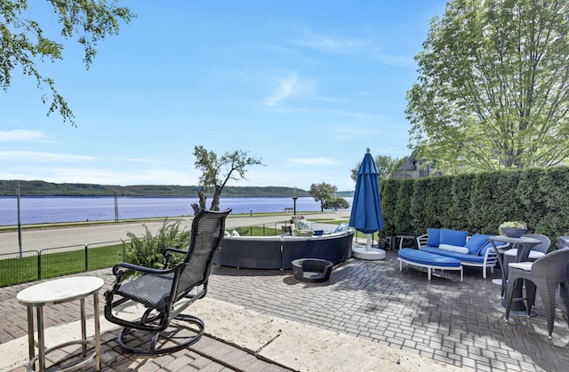 view of patio / terrace with a water view and an outdoor living space