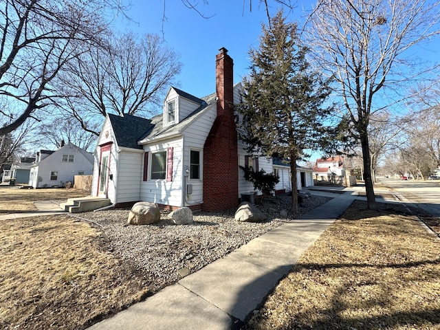 view of side of home with a chimney and a shingled roof