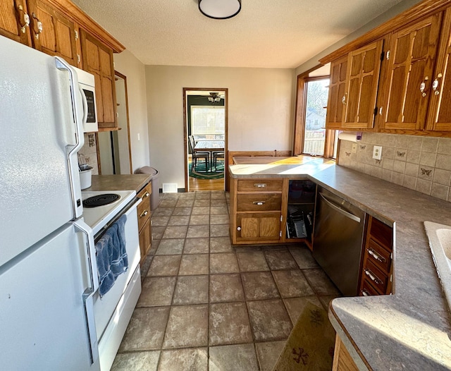 kitchen with decorative backsplash, white appliances, and brown cabinetry