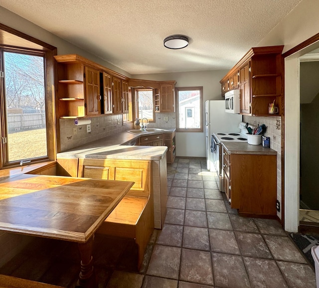 kitchen featuring white appliances, baseboards, open shelves, a sink, and tasteful backsplash