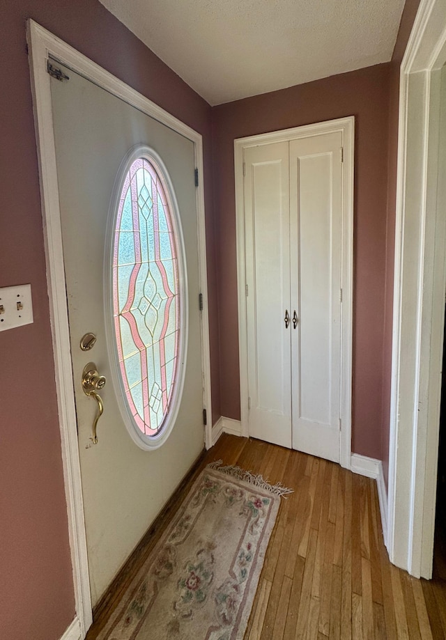 foyer entrance with baseboards and wood finished floors