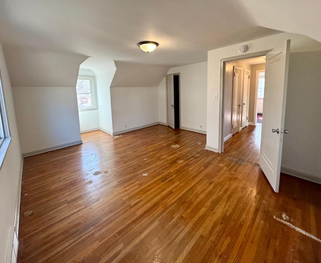 bonus room with vaulted ceiling, wood finished floors, and baseboards