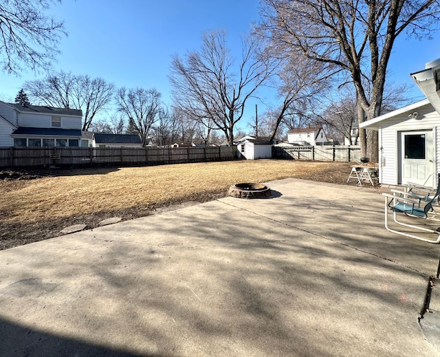 view of yard featuring a fenced backyard, a shed, an outdoor fire pit, an outdoor structure, and a patio area