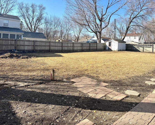 view of yard featuring an outbuilding, a fenced backyard, and a shed