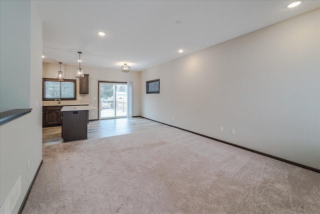 unfurnished living room featuring light carpet