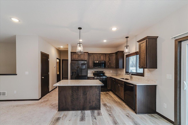 kitchen featuring a kitchen island, pendant lighting, sink, dark brown cabinetry, and black appliances