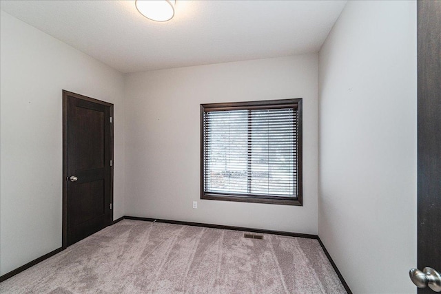 unfurnished room with light colored carpet