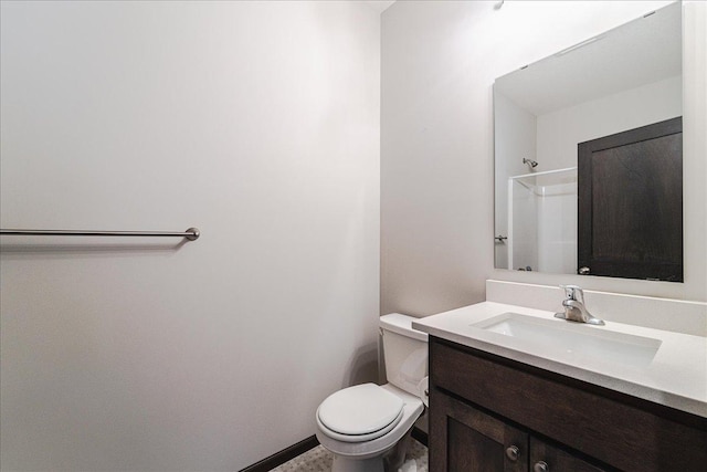 bathroom with vanity, a shower, and toilet