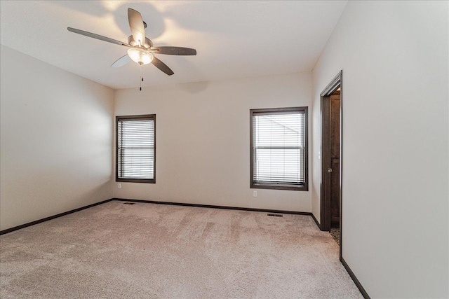 carpeted spare room with plenty of natural light and ceiling fan