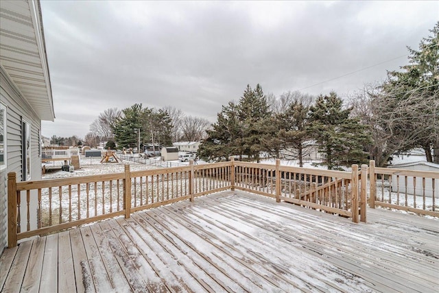 snow covered deck featuring a playground