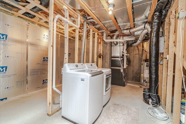 basement featuring water heater, washer and dryer, and heating unit