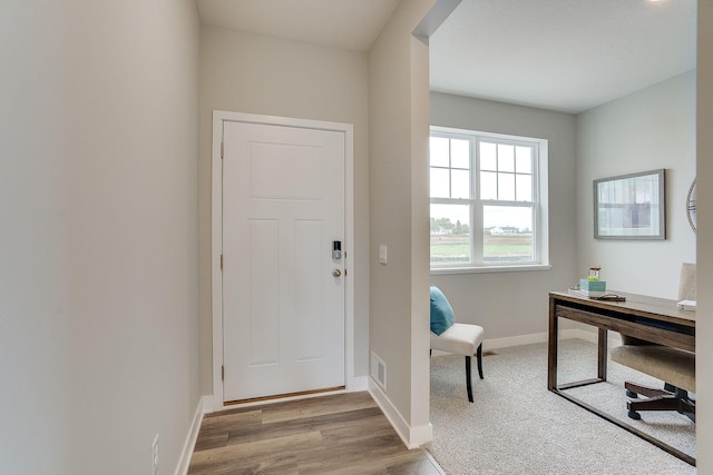 foyer entrance featuring light wood-style floors, baseboards, and visible vents