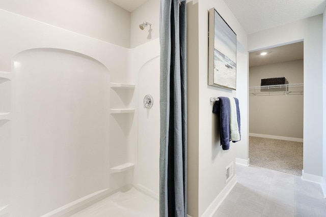 full bathroom with visible vents, a shower stall, baseboards, and a spacious closet