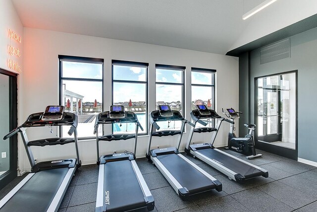 gym with vaulted ceiling and baseboards