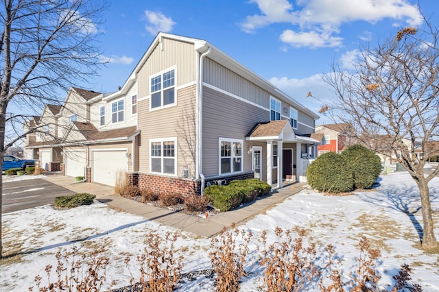 snow covered property featuring a garage