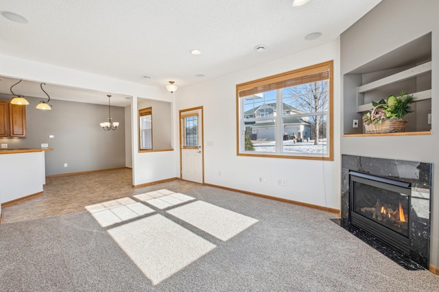 carpeted living room featuring a notable chandelier, a textured ceiling, and a fireplace