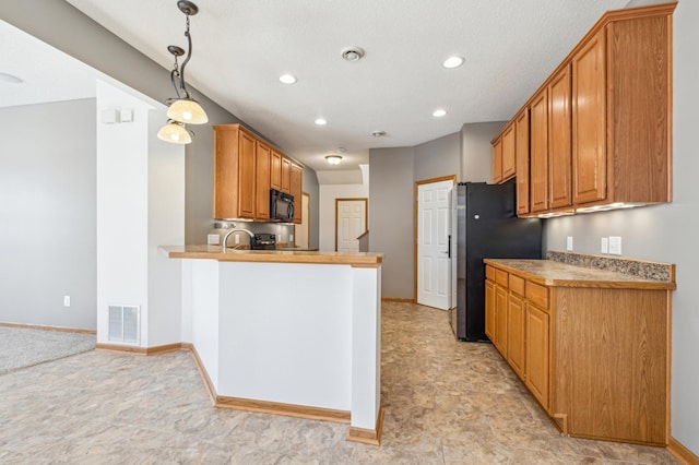 kitchen with decorative light fixtures, stainless steel refrigerator, and kitchen peninsula