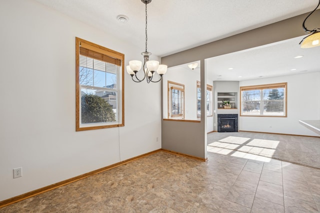 unfurnished dining area featuring carpet floors, a textured ceiling, and a notable chandelier