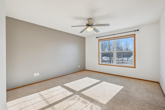 empty room with ceiling fan, light carpet, and a textured ceiling