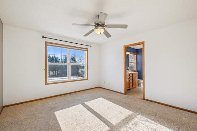 spare room with ceiling fan, light colored carpet, and a textured ceiling