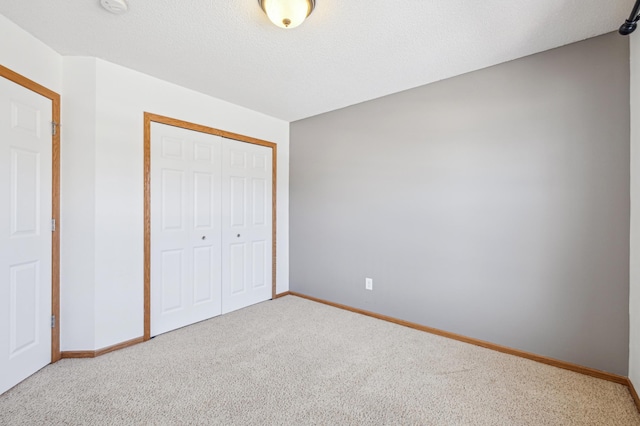 unfurnished bedroom with carpet floors, a closet, and a textured ceiling