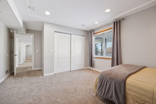 bedroom with visible vents, light carpet, and baseboards