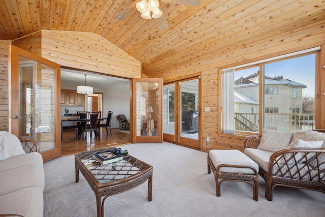 living area with lofted ceiling, wooden ceiling, light carpet, wood walls, and french doors