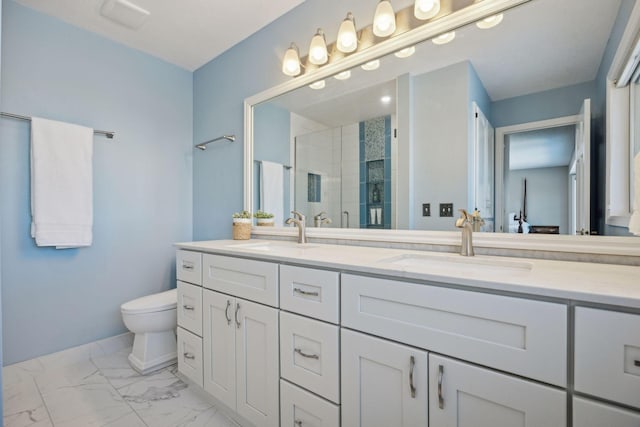 bathroom featuring a stall shower, marble finish floor, a sink, and double vanity