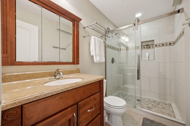 full bath with toilet, a stall shower, vanity, and tile patterned floors