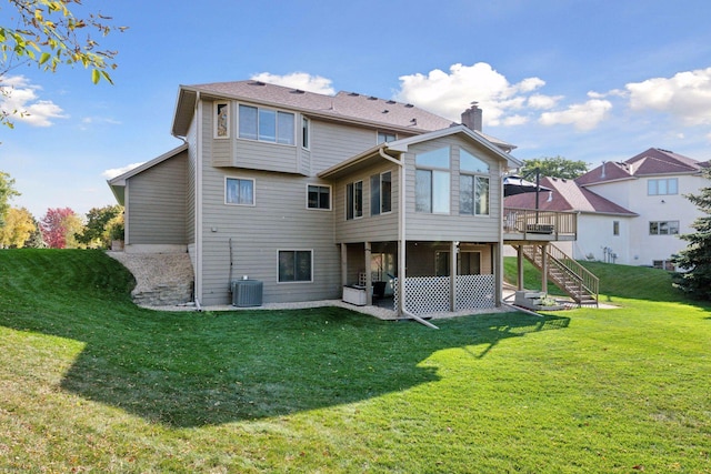 rear view of house featuring a lawn, a chimney, stairs, a wooden deck, and central AC