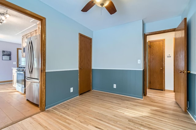 unfurnished room with light hardwood / wood-style flooring and ceiling fan