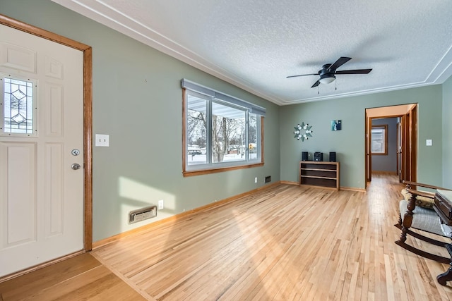 entryway with ceiling fan, light hardwood / wood-style flooring, and a textured ceiling