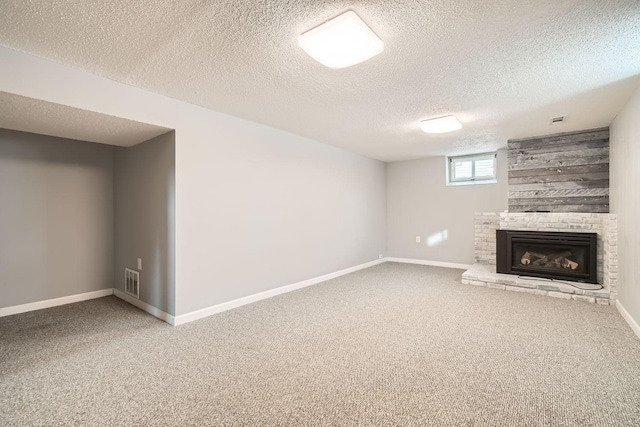 basement with a fireplace, carpet flooring, and a textured ceiling