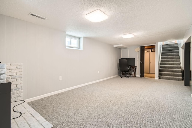 basement with carpet flooring, a brick fireplace, and a textured ceiling