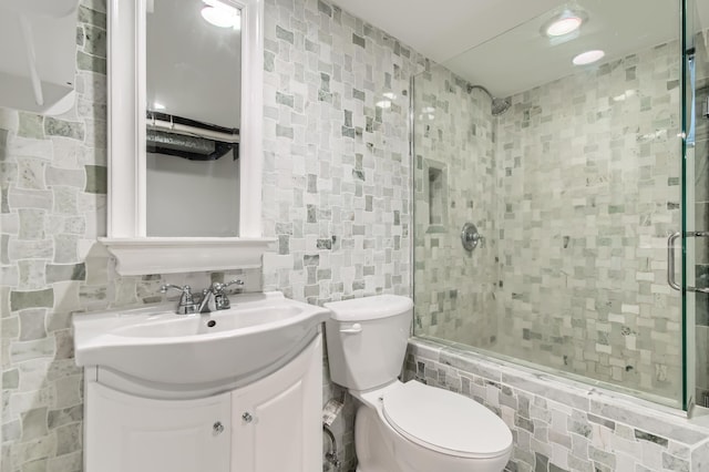 bathroom featuring vanity, decorative backsplash, tile walls, and toilet