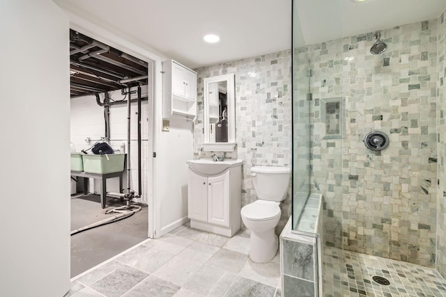 bathroom with vanity, toilet, and tiled shower