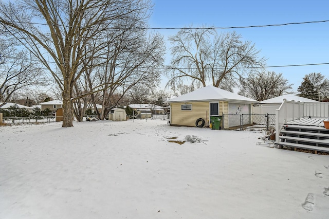 yard layered in snow with a storage shed