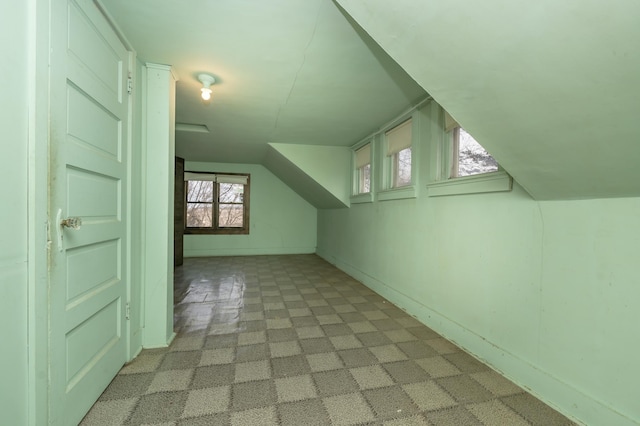 bonus room featuring vaulted ceiling and light carpet