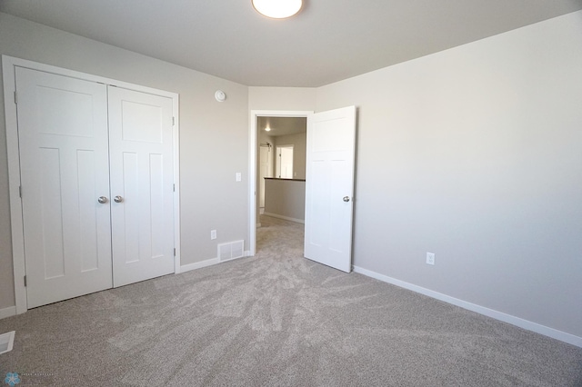 unfurnished bedroom with a closet and light carpet