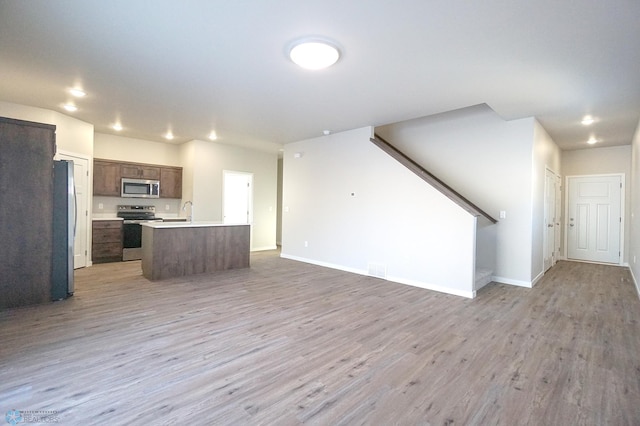 6020 80th Ave S, Fargo, ND 58047 - kitchen featuring appliances with stainless steel finishes, open floor plan, light wood-type flooring, light countertops, and recessed lighting