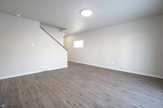 6020 80th Ave S, Fargo, ND 58047 - empty room featuring wood finished floors, stairway, baseboards, and a smoke detector