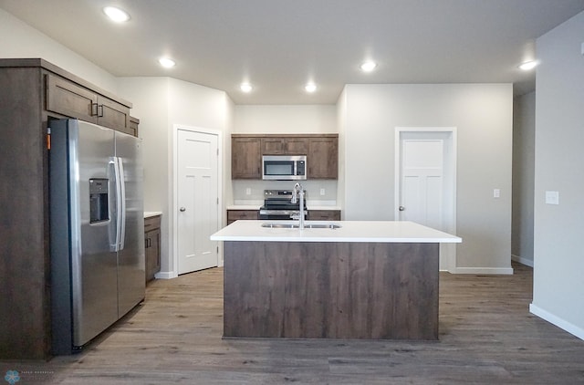 6020 80th Ave S, Fargo, ND 58047 - kitchen featuring stainless steel appliances, a sink, a center island with sink, wood finished floors, and recessed lighting