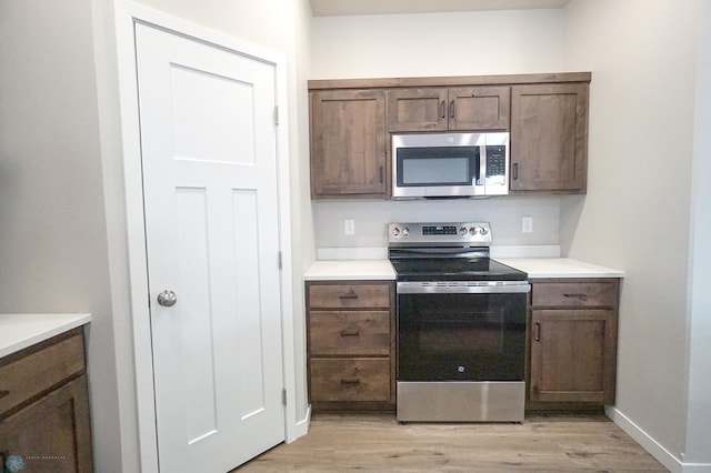 6020 80th Ave S, Fargo, ND 58047 - kitchen featuring appliances with stainless steel finishes, light wood-type flooring, light countertops, and dark brown cabinets