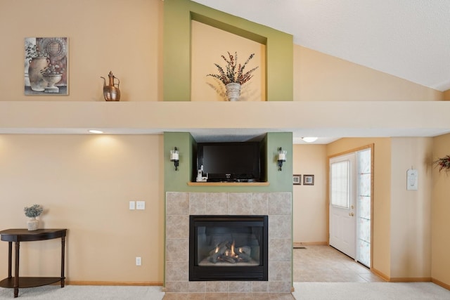 living room featuring a tiled fireplace, tile patterned floors, and lofted ceiling