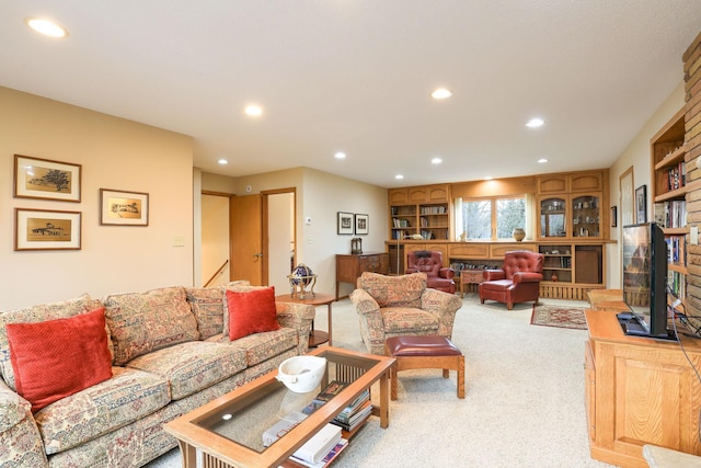 living room with recessed lighting, a large fireplace, and light colored carpet