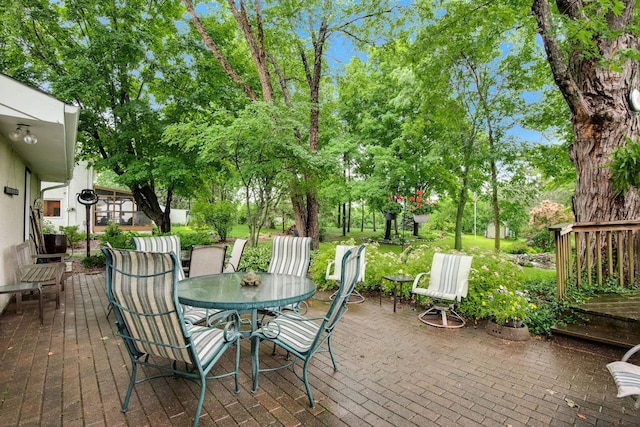 wooden deck featuring outdoor dining space and a patio