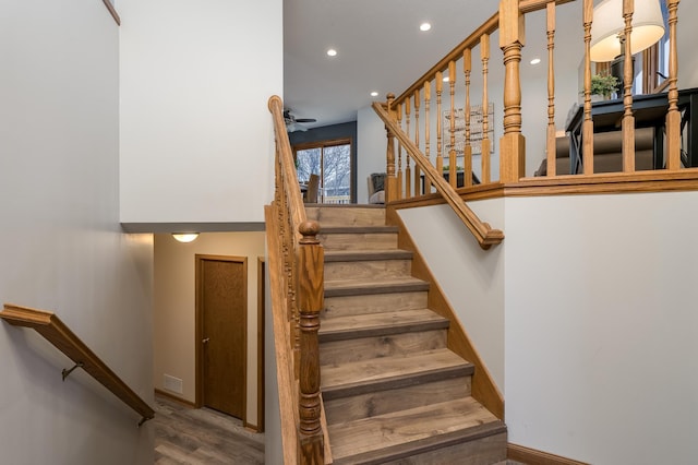 stairway featuring ceiling fan and hardwood / wood-style floors