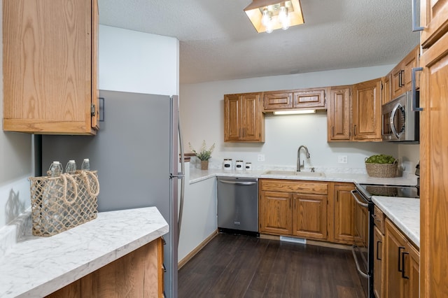 kitchen featuring dark hardwood / wood-style flooring, sink, stainless steel appliances, and a textured ceiling