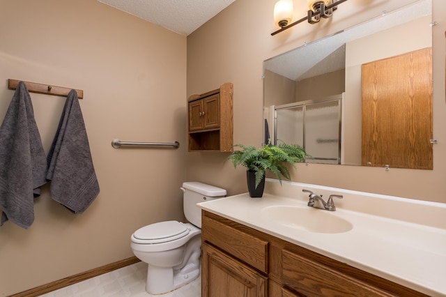 bathroom with vanity, a shower with shower door, and toilet